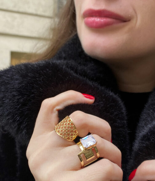 bague plaque en maille plaqué or portée par une femme brune au rouge à lèvre rouge