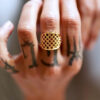 bague portée par une main tatouée plaqué or jaune