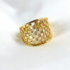 bague plaque or posée sur un fond blanc en maille de métal plaqué or jaune