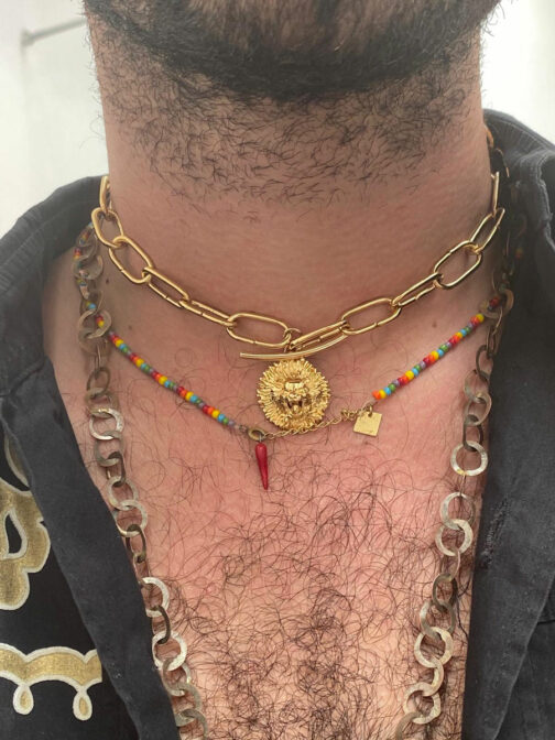 pendentif astrologique collier tête de lion avec une grosse chaine porté par un homme avec un collier multicolore