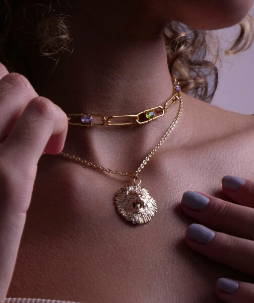 collier avec une tête de lion et une chaine porté sur une femme en signe astrologique