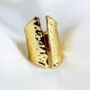 large bague femme aqua move couleur or jaune posée sur un tissu blanc